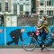 Photo 7: Eine Radlerin passiert den beklebtenZaun an der Baustelle der neuen U-Bahn, Amsterdam 2013 © Werner Mansholt